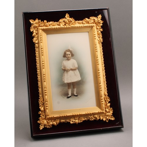 2566 - Photography - an early 20th century presentation studio portrait photograph, of a young girl, colour... 