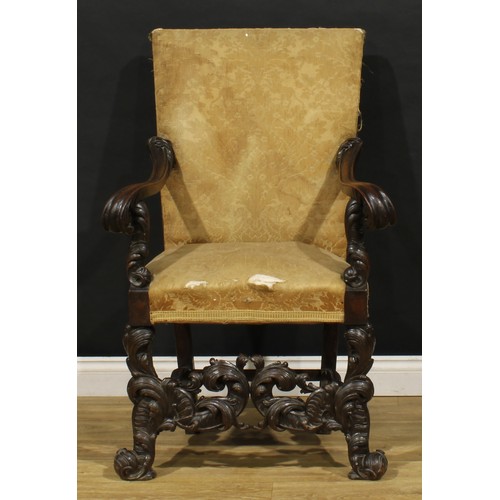 1519 - An Italian Baroque Revival armchair, stuffed-over upholstery, shaped arms terminating in leafy scrol... 