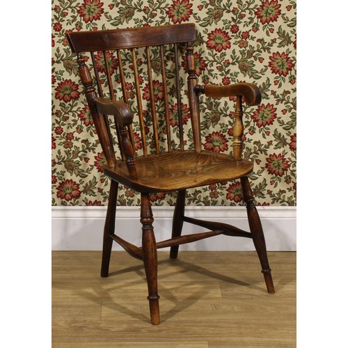 2406 - A 19th century vernacular elm and ash Windsor elbow chair, stick back with curved cresting rail flan... 