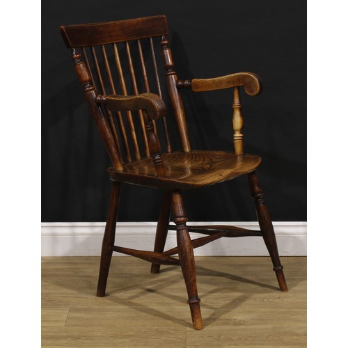 2406 - A 19th century vernacular elm and ash Windsor elbow chair, stick back with curved cresting rail flan... 