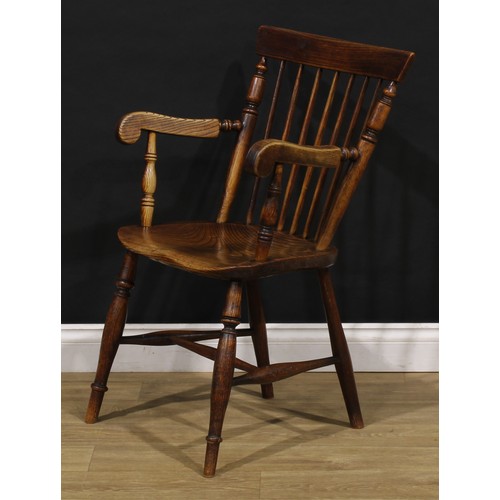 2406 - A 19th century vernacular elm and ash Windsor elbow chair, stick back with curved cresting rail flan... 