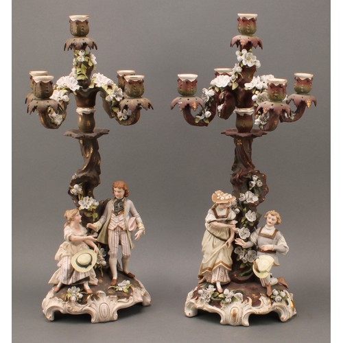 259 - A pair of Sitzendorf porcelain figural five-light candelabra, modelled as courting couples, each pai... 