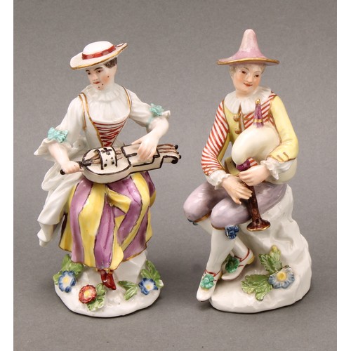 280 - An 18th century porcelain figure, Harlequin, he sits with bagpipes, blue crossed sword mark, 13.5cm ... 