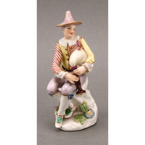 280 - An 18th century porcelain figure, Harlequin, he sits with bagpipes, blue crossed sword mark, 13.5cm ... 