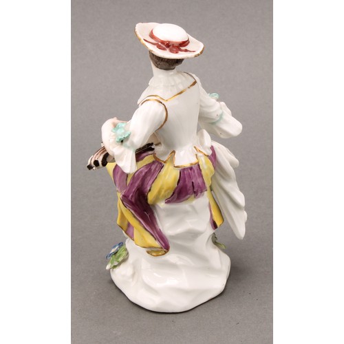 280 - An 18th century porcelain figure, Harlequin, he sits with bagpipes, blue crossed sword mark, 13.5cm ... 