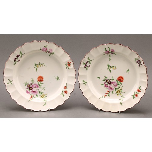 127 - A pair of 18th century Worcester shaped circular dished plates, decorated in polychrome in the Meiss... 