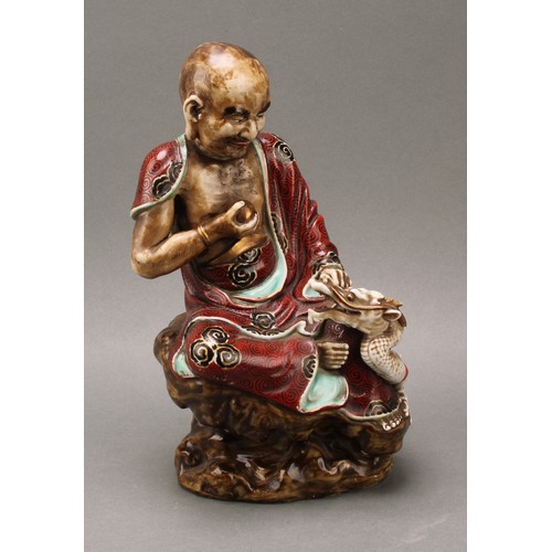 1298 - A Japanese porcelain figure, of a sage holding the pearl of wisdom, a dragon at his side, decorated ... 