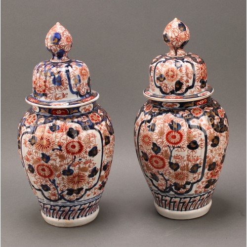 1365 - A pair of Japanese fluted ovoid vases and covers, painted in the Imari palette, 37cm high, Meiji per... 