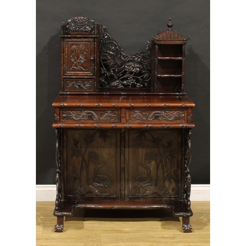 1891 - A Chinese export hardwood desk, shaped superstructure with panel door, small drawer and open shelves... 