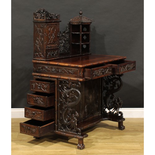 1891 - A Chinese export hardwood desk, shaped superstructure with panel door, small drawer and open shelves... 