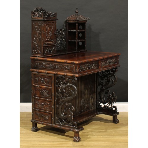 1891 - A Chinese export hardwood desk, shaped superstructure with panel door, small drawer and open shelves... 