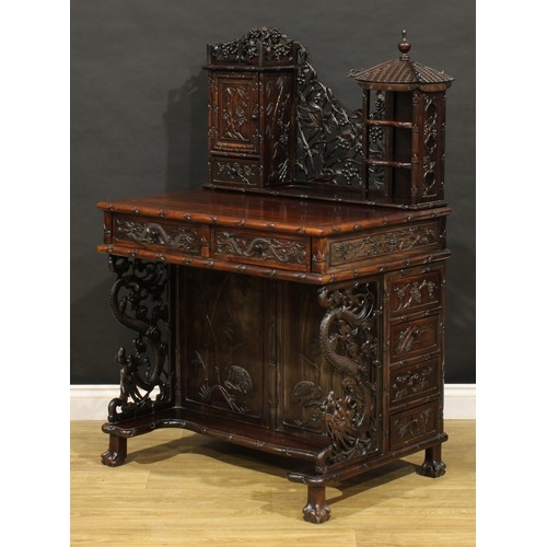 1891 - A Chinese export hardwood desk, shaped superstructure with panel door, small drawer and open shelves... 