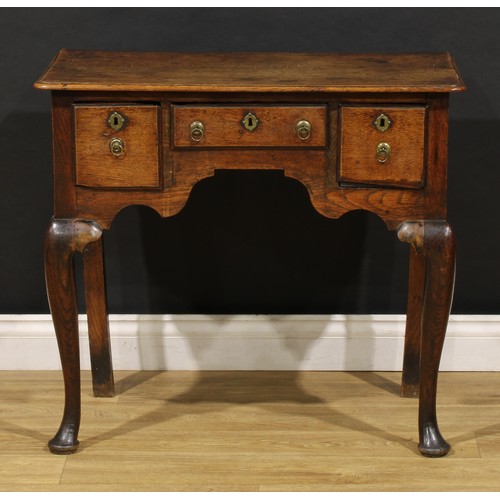 2360 - A George II oak lowboy, rounded rectangular moulded oversailing top above three frieze drawers, shap... 