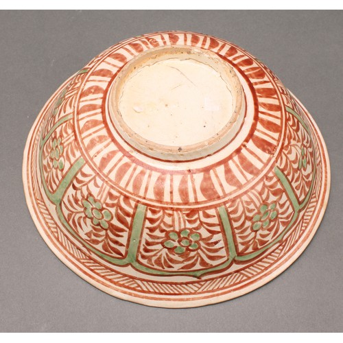 1311 - A Middle Eastern pottery circular bowl, decorated in the Islamic taste in tones of red and green wit... 