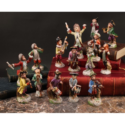 31 - A German porcelain monkey band, inspired by models by Kändler, the conductor 15.5cm high