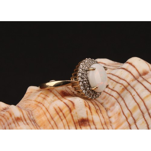 1192 - A 9ct gold white opal and diamond cluster ring, consisting of an oval cabochon opal that measures ap... 