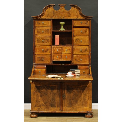 2413 - An 18th century German walnut bureau cabinet, architectural pediment above an arrangement of drawers... 