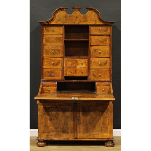 2413 - An 18th century German walnut bureau cabinet, architectural pediment above an arrangement of drawers... 