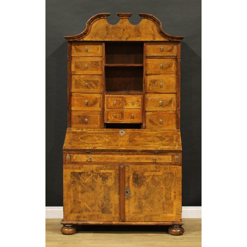 2413 - An 18th century German walnut bureau cabinet, architectural pediment above an arrangement of drawers... 