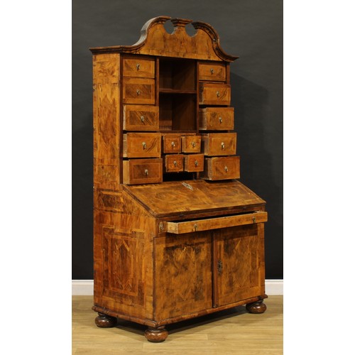 2413 - An 18th century German walnut bureau cabinet, architectural pediment above an arrangement of drawers... 