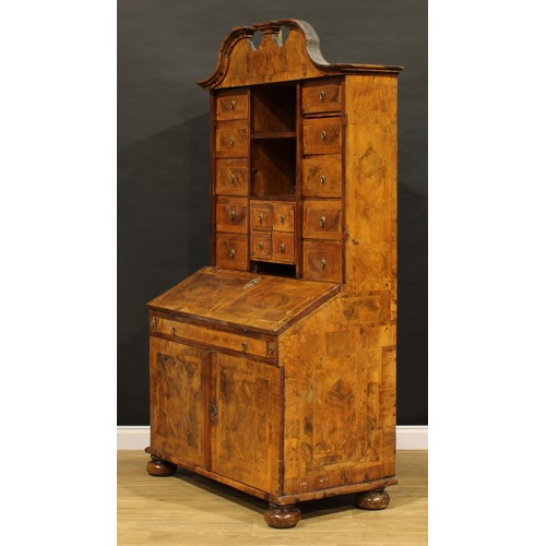 2413 - An 18th century German walnut bureau cabinet, architectural pediment above an arrangement of drawers... 