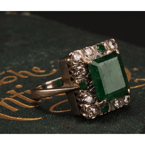 1199 - A diamond and emerald ring, the canted rectangular tablet claw set above a border of diamonds inters... 