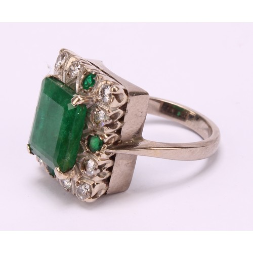 1199 - A diamond and emerald ring, the canted rectangular tablet claw set above a border of diamonds inters... 