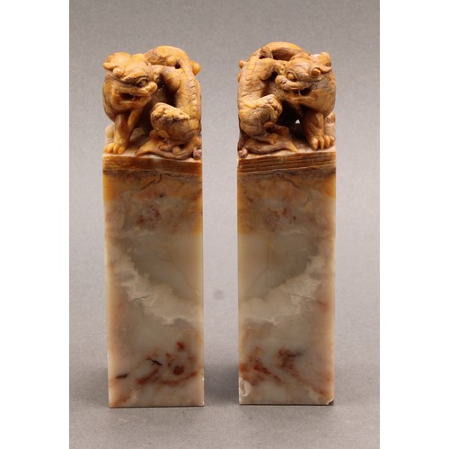 1374 - A pair of Chinese hardstone desk seals, each carved with a temple lion and young, 14.5cm high, later... 