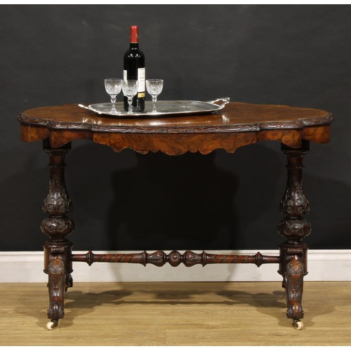 2463 - A Victorian walnut centre table, probably Irish, quarter-veneered top with carved edge, baluster end... 