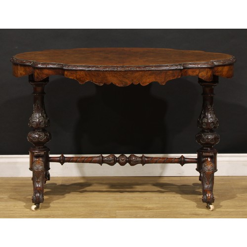 2463 - A Victorian walnut centre table, probably Irish, quarter-veneered top with carved edge, baluster end... 