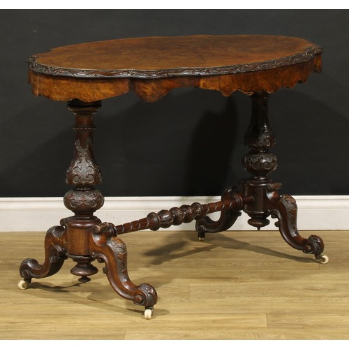 2463 - A Victorian walnut centre table, probably Irish, quarter-veneered top with carved edge, baluster end... 