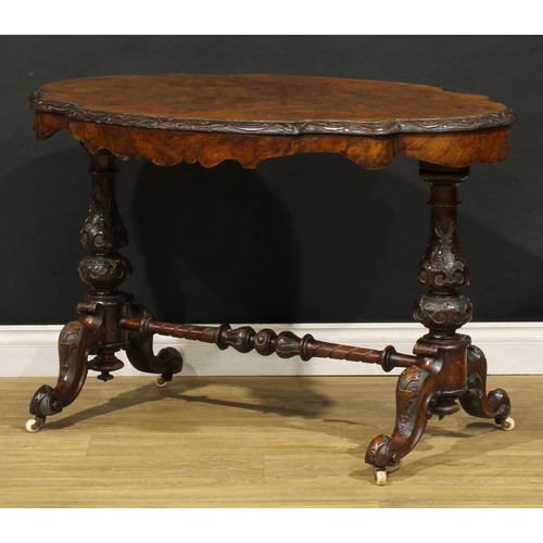 2463 - A Victorian walnut centre table, probably Irish, quarter-veneered top with carved edge, baluster end... 