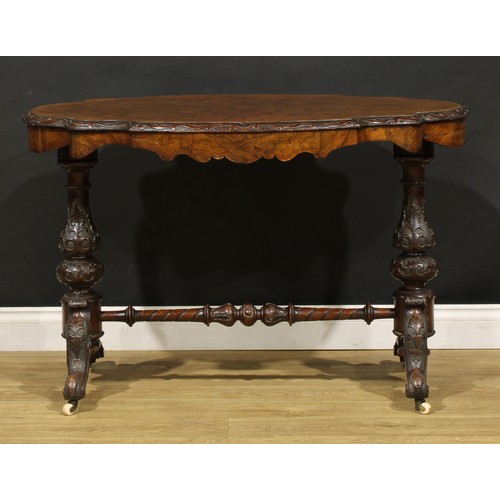 2463 - A Victorian walnut centre table, probably Irish, quarter-veneered top with carved edge, baluster end... 