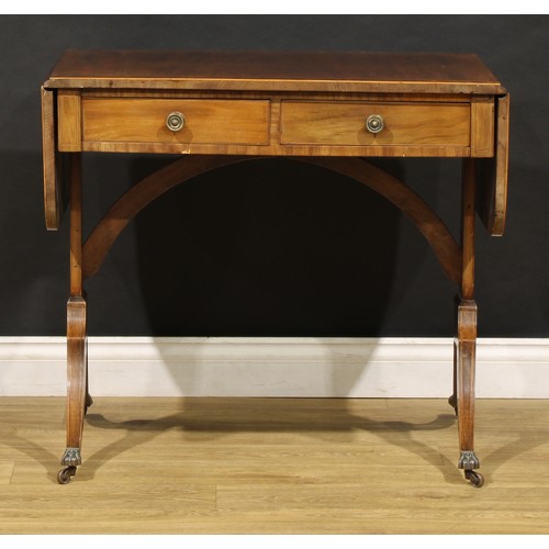 2094 - A 19th century mahogany sofa table, in the Regency taste, rounded rectangular top with fall leaves a... 