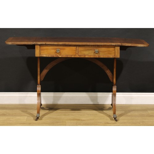 2094 - A 19th century mahogany sofa table, in the Regency taste, rounded rectangular top with fall leaves a... 