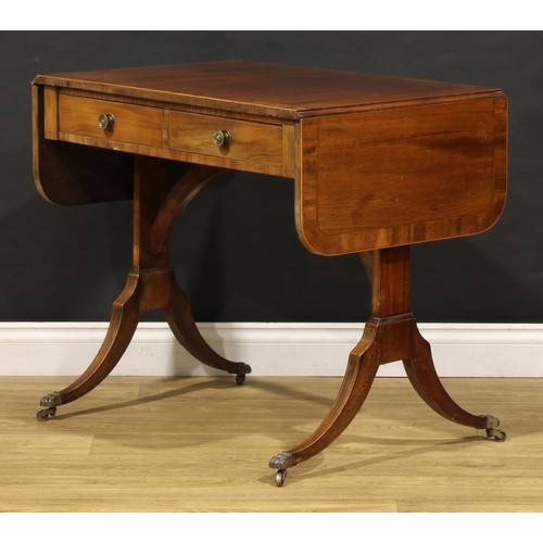 2094 - A 19th century mahogany sofa table, in the Regency taste, rounded rectangular top with fall leaves a... 