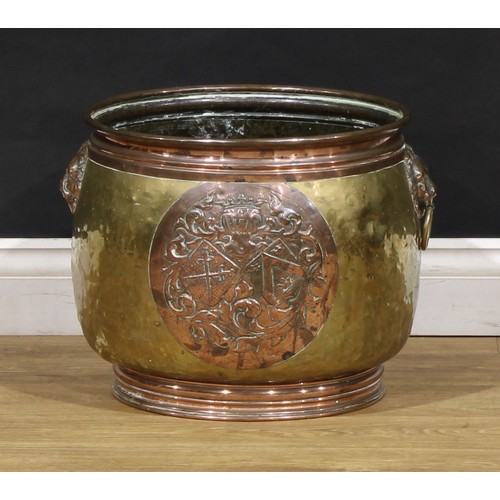 2355 - A Dutch brass and copper fireside fuel bin, embossed with an armorial, 34.5cm high, 38cm diameter, e... 