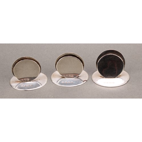 914 - A set of three George V silver circular menu holders, oval bases, 3.5cm high, Martin Hall & Co., Bir... 