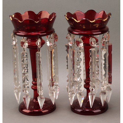 295 - A pair of Victorian ruby glass table or mantel lustres, each applied with gilt motifs, prismatic cut... 