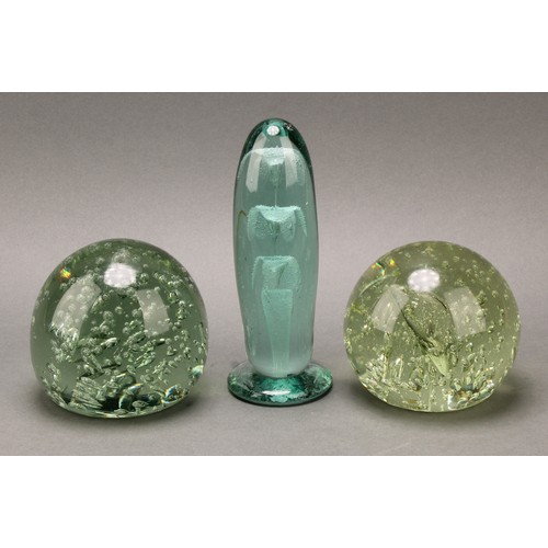 298 - A Victorian elongated green glass dump, flower inclusions issuing from a vase, spreading circular ba... 