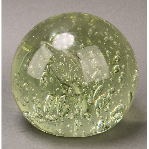 298 - A Victorian elongated green glass dump, flower inclusions issuing from a vase, spreading circular ba... 