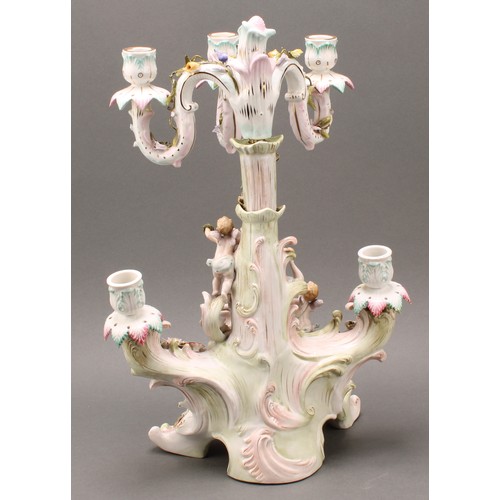 223 - A Continental porcelain figural five-branch candelabra, as a maiden seated beside a tree, with two c... 