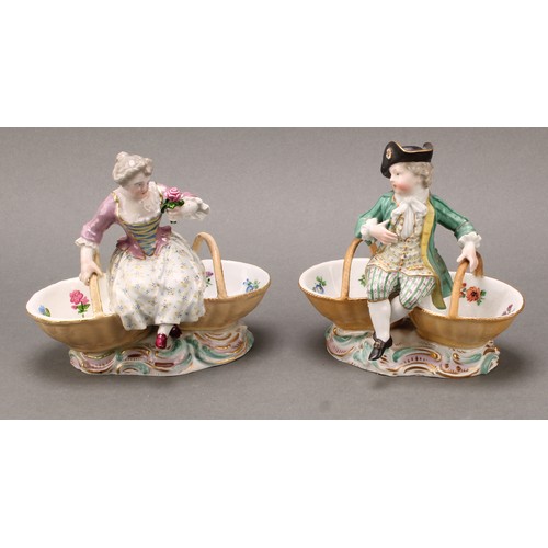 253 - A pair of German porcelain figural table salts, of a gallant and companion, each seated between two ... 