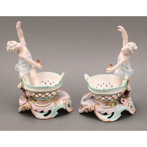 253 - A pair of German porcelain figural table salts, of a gallant and companion, each seated between two ... 