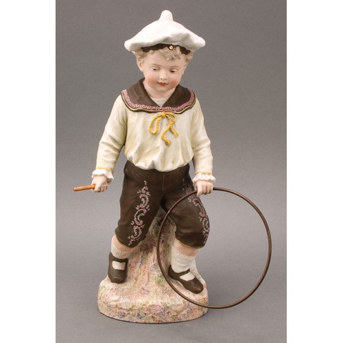 243 - A pair Gebrüder Heubach bisque figures, of a boy and girl at play, he with hoop and stick, she with ... 