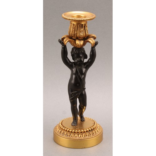 2083 - A pair of French Bronze and ormolu candlesticks, bronze cherub columns arms erect holding a gilt lea... 