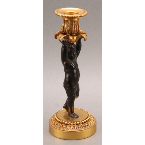 2083 - A pair of French Bronze and ormolu candlesticks, bronze cherub columns arms erect holding a gilt lea... 