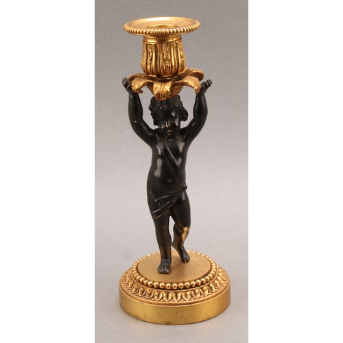 2083 - A pair of French Bronze and ormolu candlesticks, bronze cherub columns arms erect holding a gilt lea... 