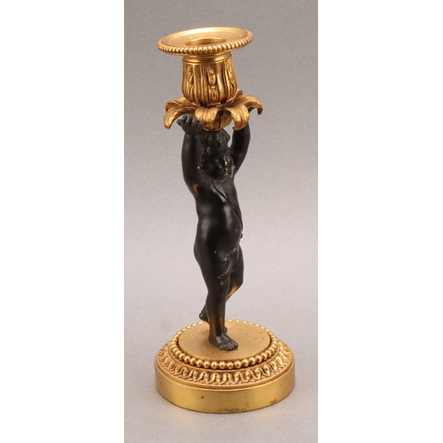 2083 - A pair of French Bronze and ormolu candlesticks, bronze cherub columns arms erect holding a gilt lea... 