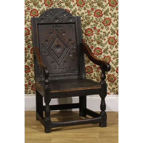 1880 - A 17th century oak wainscot armchair, carved panel back with arched cresting, downswept arms, turned... 